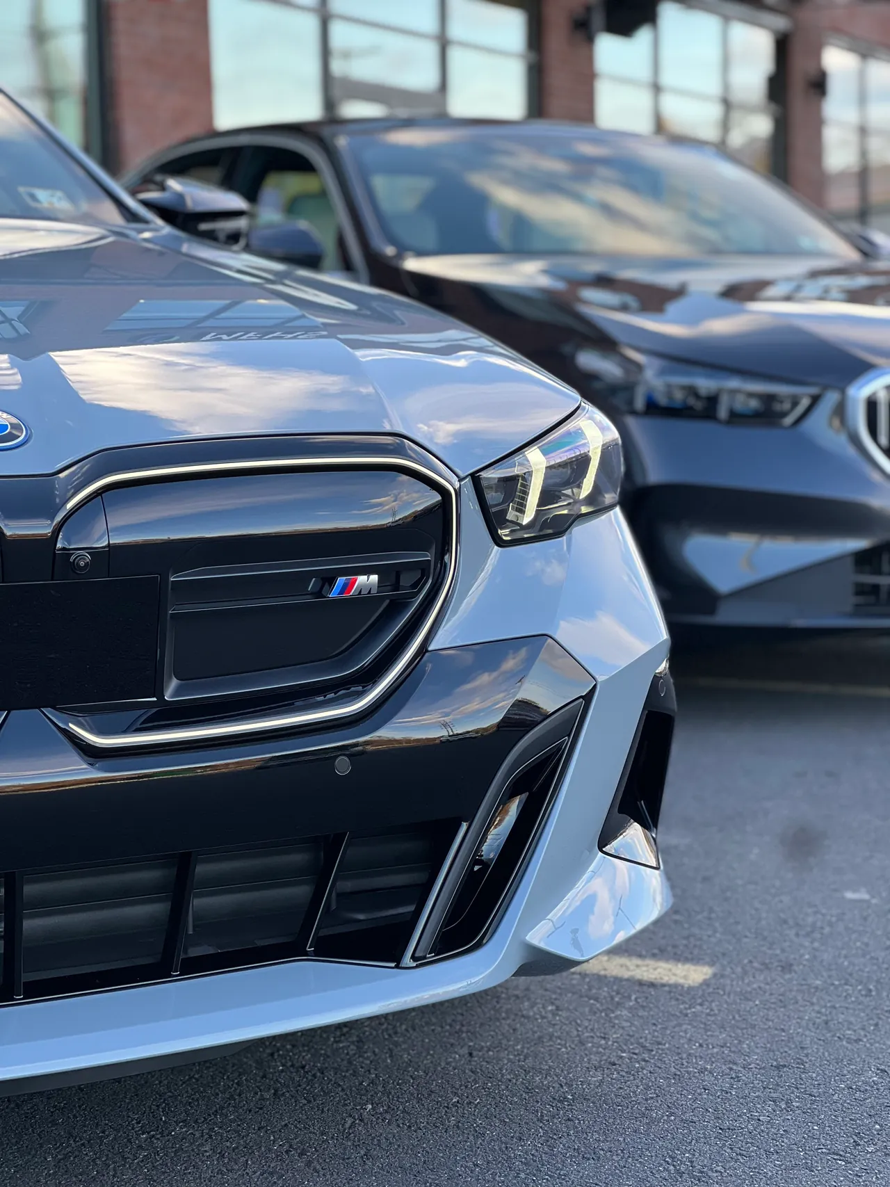 Front grille and headlight of a silver sedan on a dealer lot